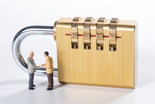 business miniature people try to unlock security lock key