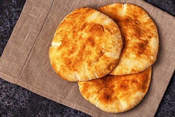 Pita bread on a dark table.