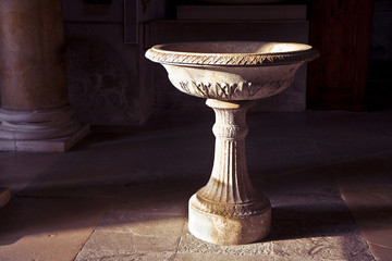 Inlaid marble holy water font in an Italian church (Italy) - image with copy space - obrazy, fototapety, plakaty