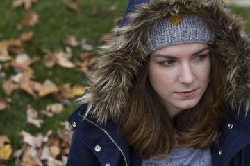 Portrait of a young woman wearing hood in autumn. Soft focus