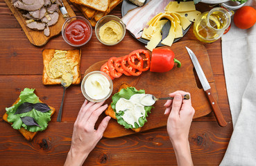 the hostess prepares a sandwich on a wooden table for guests