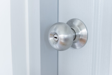 white door with metal doorknob is regular lock style in a house, copy space.