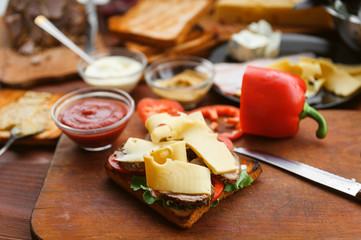 the hostess prepares a sandwich on a wooden table for guests