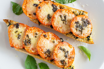 baguette roasted with tomatoes, olive oil, garlic, parmesan, and basil (leafs and paste)