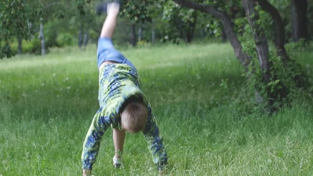 Boy jumps backflip somersault in the park in slow motion. 1920x1080