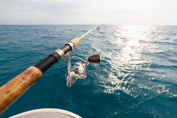 Canne à pêche de pêcheur sur le plan rapproché de coucher du soleil