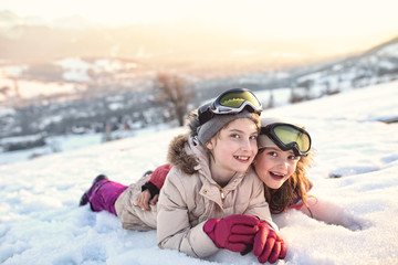 Fototapeta na wymiar Happy and cheerful girls spend time outside on a winter day