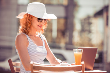 Beautiful  woman using laptop in restaurante.