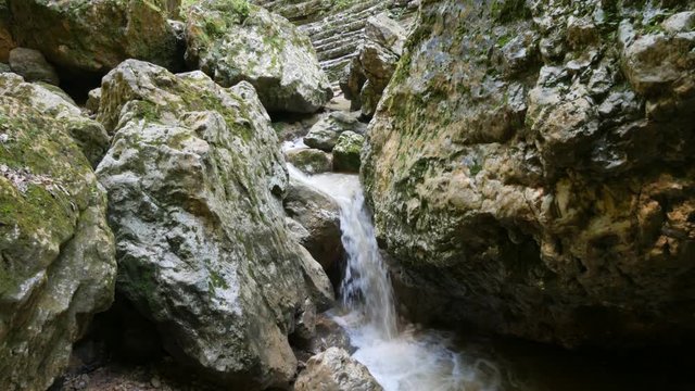 Panning shot of mountain stream among stones