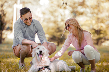 Fototapeta premium Couple with their dog in the park on a sunny day.