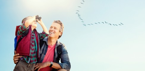 Composite image of little boy using binocular with his father 