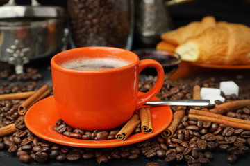 Still life with an orange mug in coffee grains