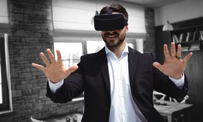 Composite image of smiling businessman using virtual reality