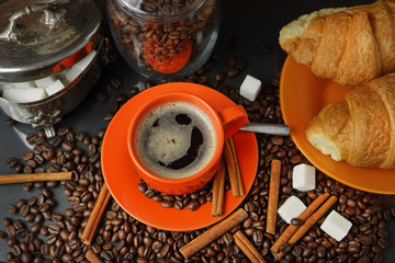 Still life with an orange mug in coffee grains