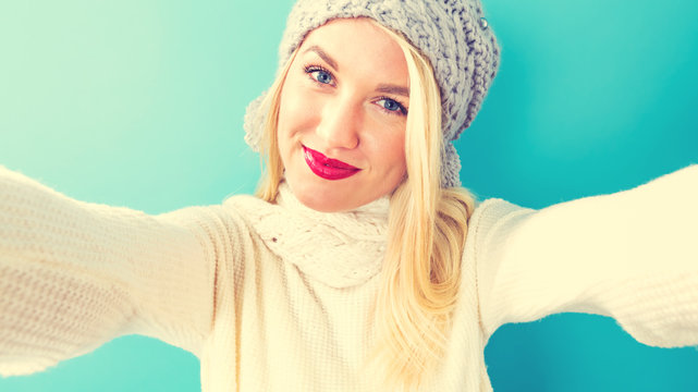 Young woman in winter clothes taking a selfie