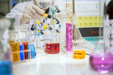 Asian scientists are experimenting with measuring pH in a chemical laboratory.
