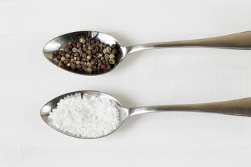 salt and pepper on metal spoons