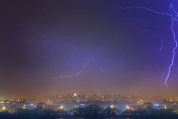 Lightning over the city at the summer storm. Dramatic, breathtaking atmospheric natural phenomenon.