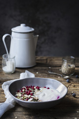 Colazione salutare e proteica a base di yogurt con fiocchi d'avena, semi di zucca, pistacchi, nocciole e ribes