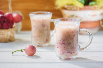 Grape smoothie over the white table.