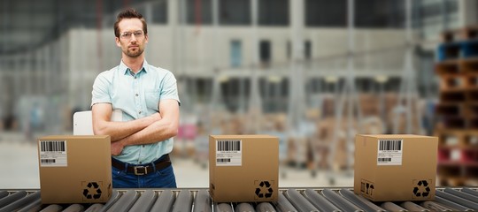 Composite image of serious warehouse manager standing with arms