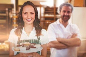 Composite image of portrait of female owner holding dessert