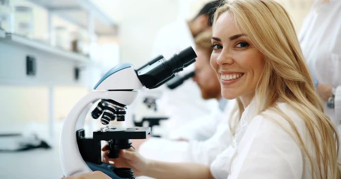 Young scientist looking through microscope in laboratory