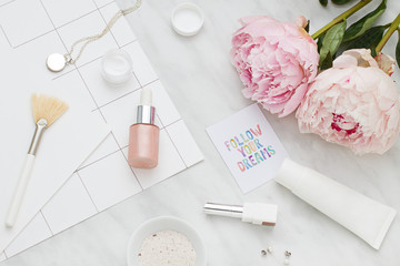 Beauty flat lay with cosmetic bottles and flower. Top view