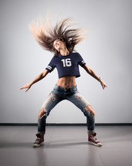 Fototapeta na wymiar modern young beautiful dancer posing on a studio background