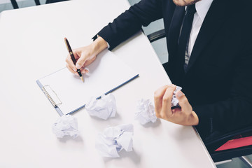 caucasian business man stress and crumpled paper