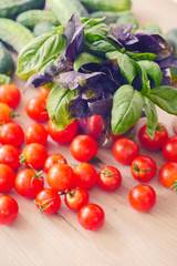 Fresh Basil and tomatoes. Cooking at Home. Preparing Healthy Salad with Basil and Tomatoes. Bunch of Basil, garlic, onions. Italian style composition. Fresh italian vegetables.