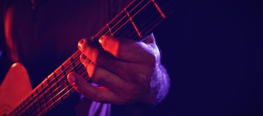 Midsection of guitarist performing