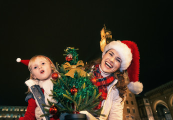 mother and child with Christmas tree having fun time in Florence