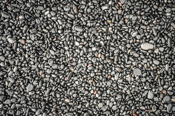 Textures of black little stones on a black stone beach in Iceland.