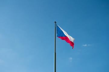 National flag of the Czech Republic. Symbol of country, state and nation is waving on the pole. Clear blue sky in the background