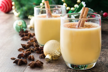 Homemade eggnog with cinnamon on wooden table. Typical Christmas dessert.
