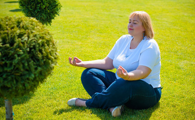 Plus size young woman, an American appearance resting in a city park, relax and rest, enjoys a beautiful day after working