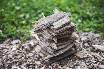  Stack of wood chips next to grass.