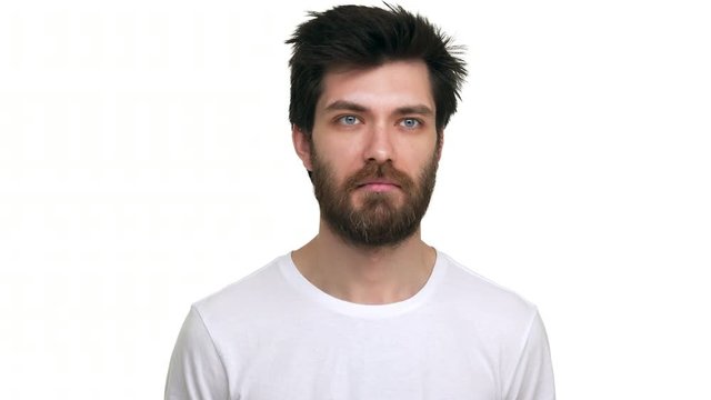 Young male agrees and nodds in surprise on white background