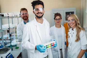 Group of young successful scientists posing for camera