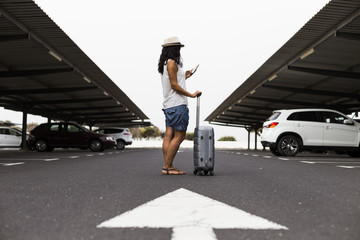 Young woman with travel bag and mobile phone at the parking airport ready for travel. concept....