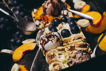 Dark food home made desert with waffles, fruits and ice cream