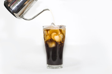 milk pour over glass of ice coffee in white background