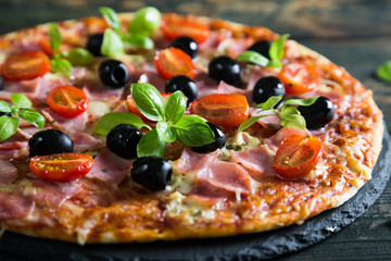 Pizza on a thin dough with olives and fresh basil
