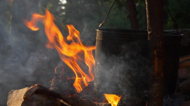 Tourist pot and camp fire. Slow motion shot