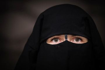 Portrait of green eyed european woman wearing in black hijab