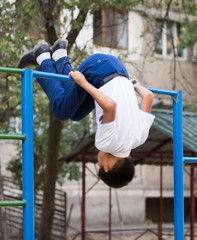 Obraz premium Boy training on a horizontal bar