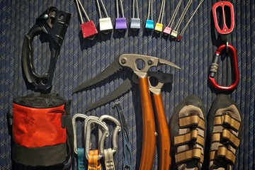 Climbing equipment laid out on a blue rope. Ascender, climbing nuts (stoppers), belay/rappel...
