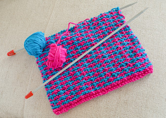 Homemade cotton dishcloths with knitting needles.