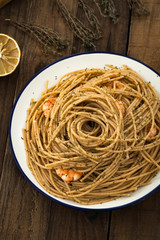 whole wheat spaghetti with shrimp on wood

